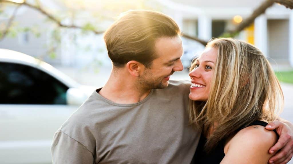 A couple hugging outdoors.