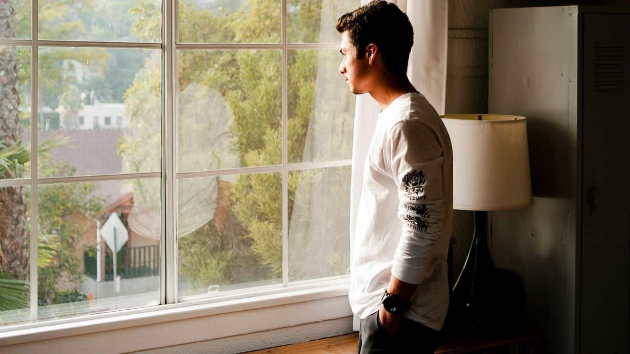 A thoughtful man looks out a window.