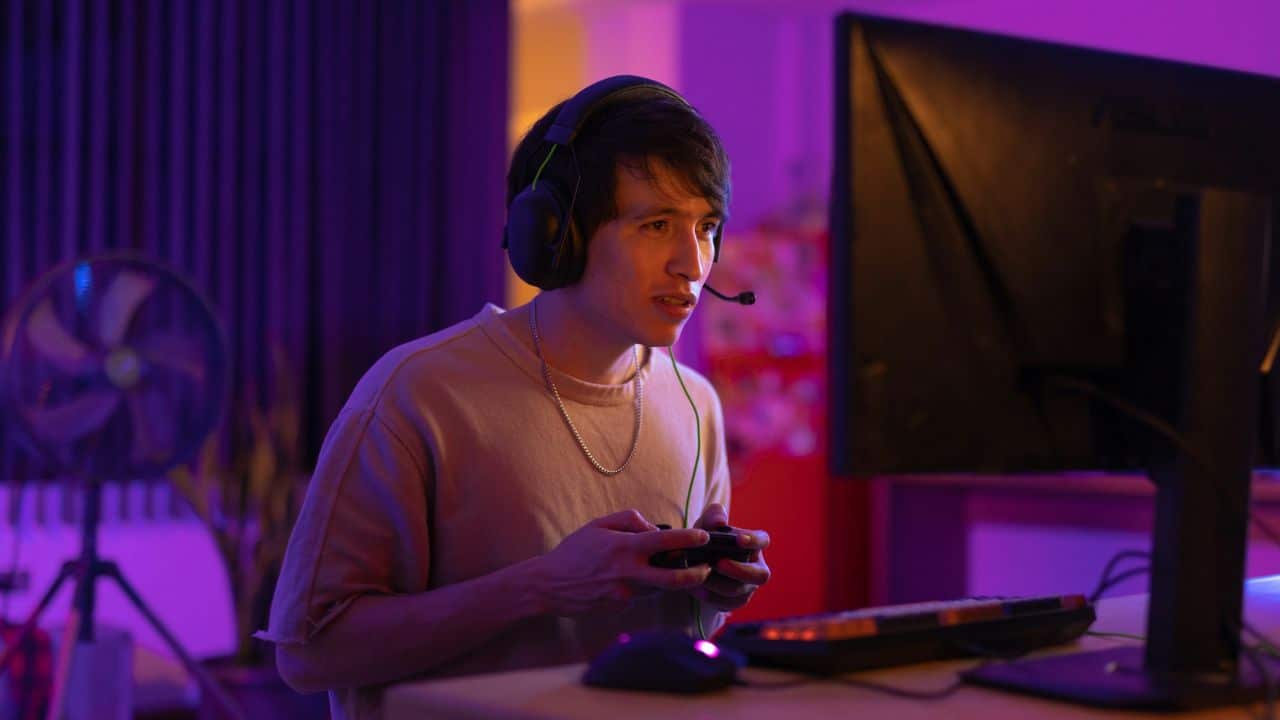 A serious person with a headset is playing a video game at night.