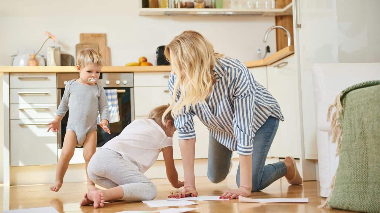 A man sits alone, wearing a flannel shirt and backpack, facing away from the camera.