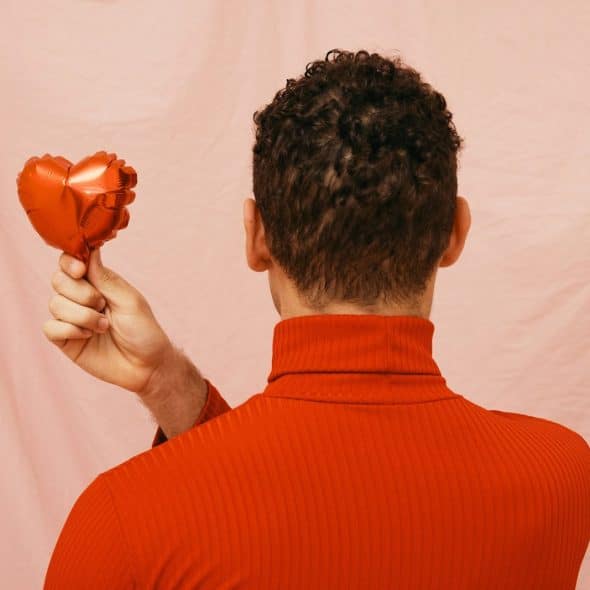 A man holding a balloon heart-shaped