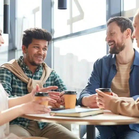 Woman smiling while talking about her partner over coffee with friends