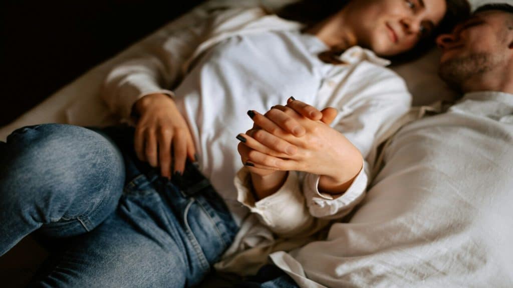 A couple cuddling in bed.