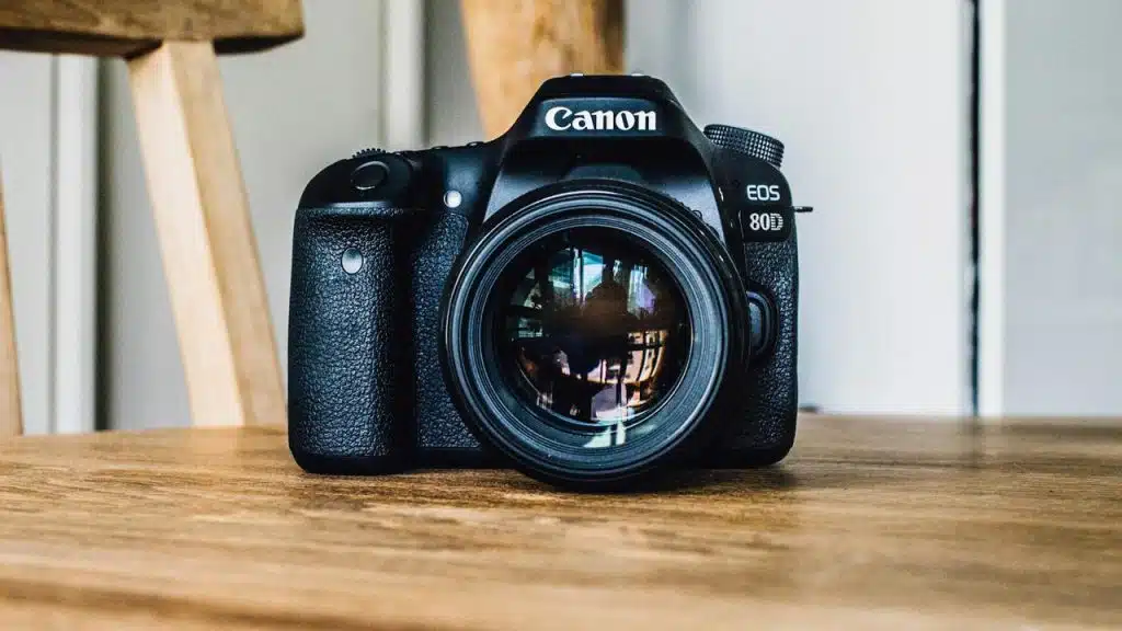 A close-up photo of a camera sitting on a wooden table.