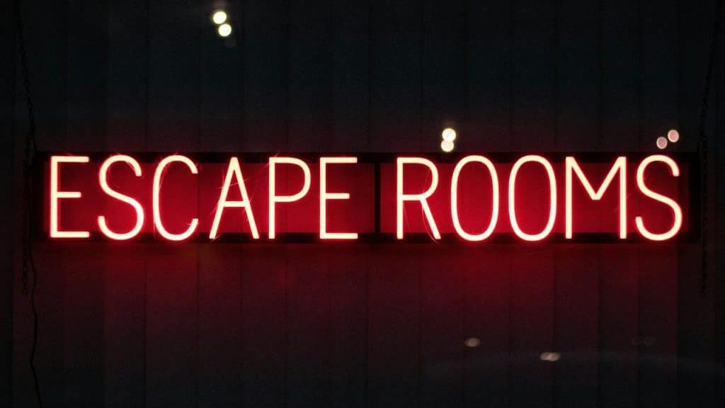 A neon sign reading "Escape Rooms" glowing in red.