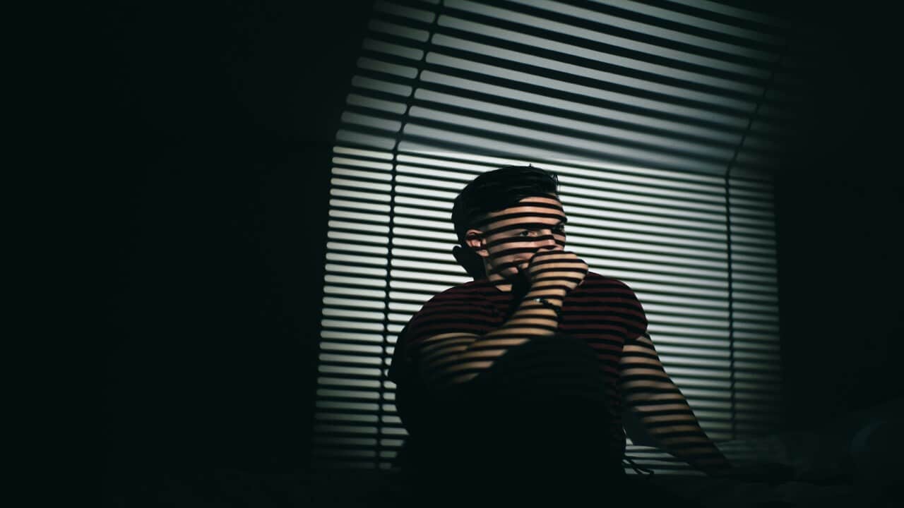 A man looking sad at home.