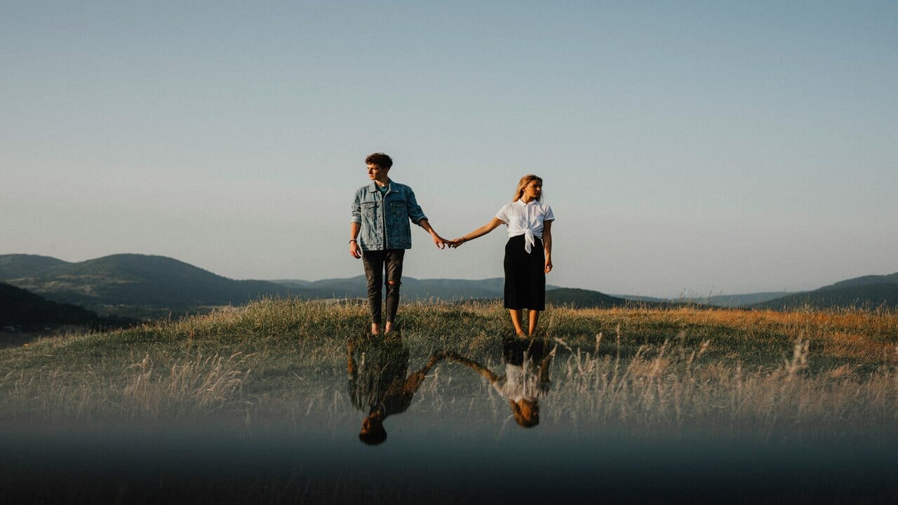 A couple standing on a field.
