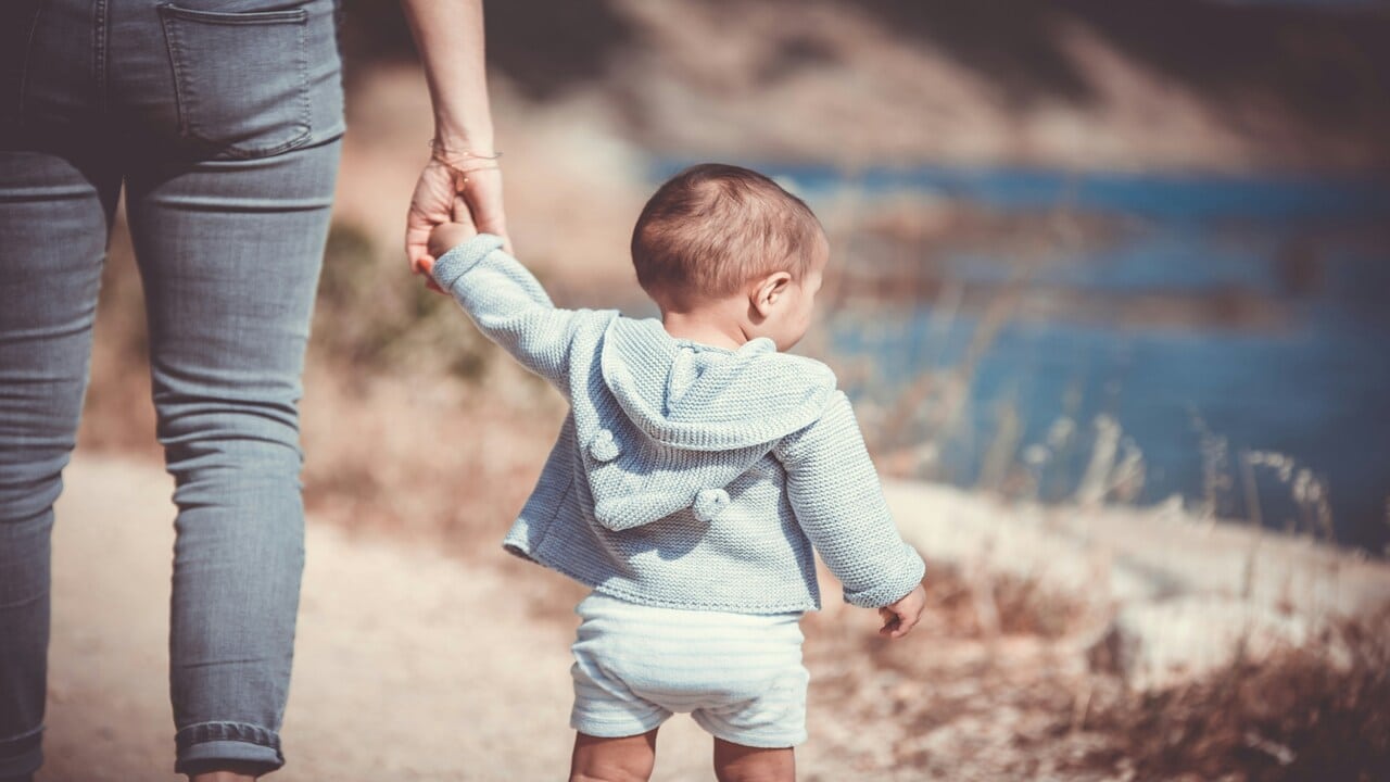 A mom walking with her baby.