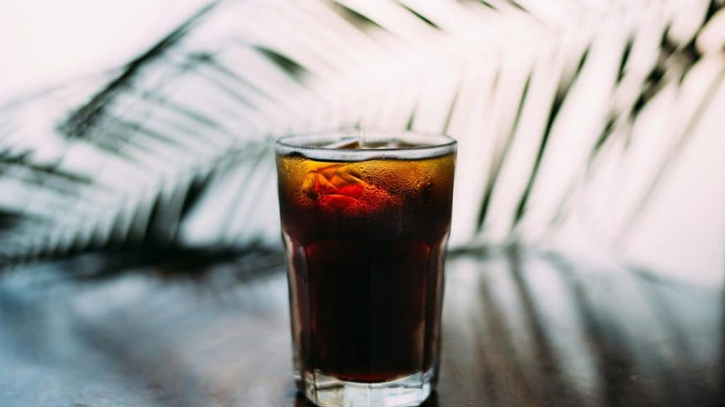 A glass of iced cola on a table.