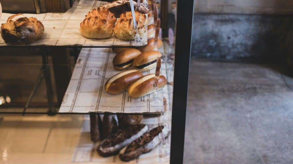 A bakery display with assorted bread and rolls.