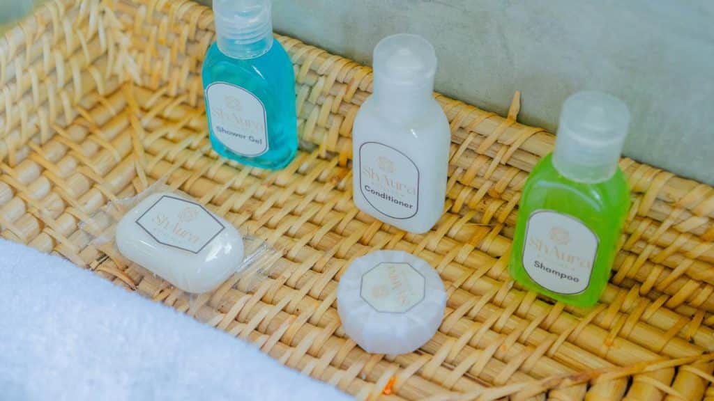 A basket with small bottles of shampoo, conditioner, shower gel, and soaps.