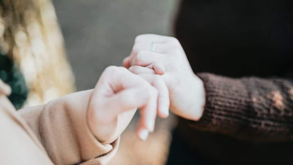 A close-up of two people holding hands.