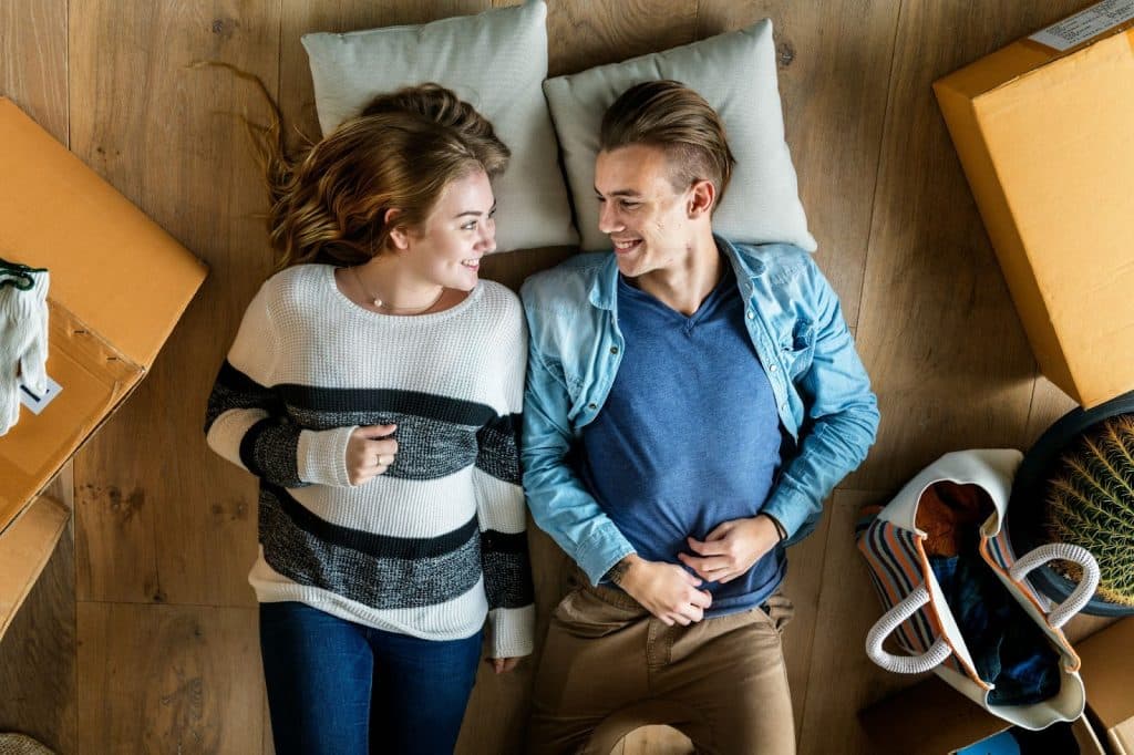 A man and woman laying at the floor 