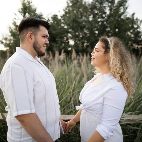 A man and woman holding hands while facing each other