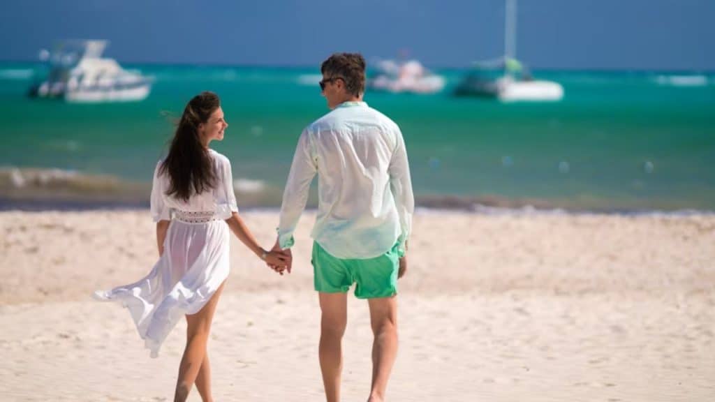 Couple walking barefoot along a quiet beach
