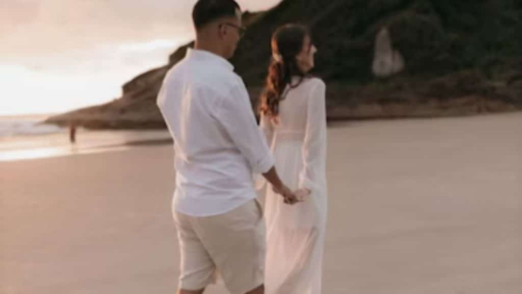 Couple walking hand in hand along a secluded beach