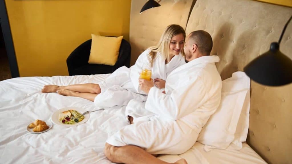 Couple enjoying a staycation breakfast in a hotel suite