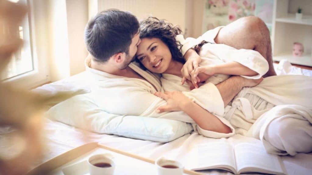 Couple embracing in soft morning light, genuine eye contact