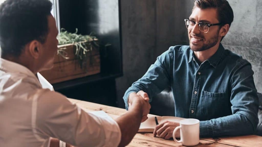 Handshake between two men over a casual café table