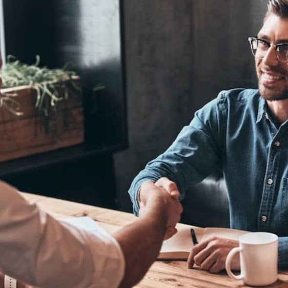 Handshake between two men over a casual café table