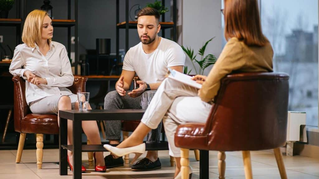 A couple talking to a therapist during a counseling session.