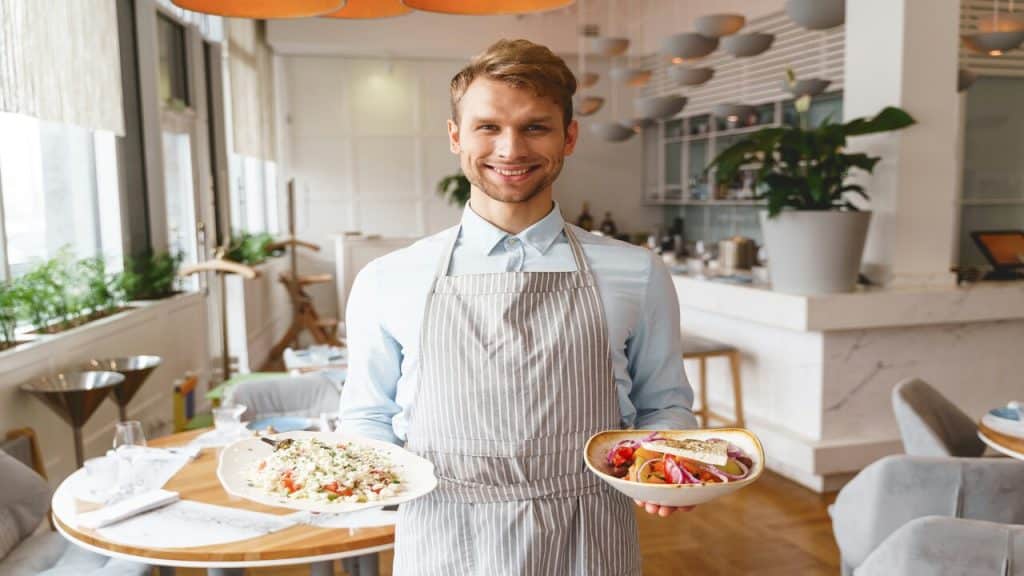 A server holding dishes of food.