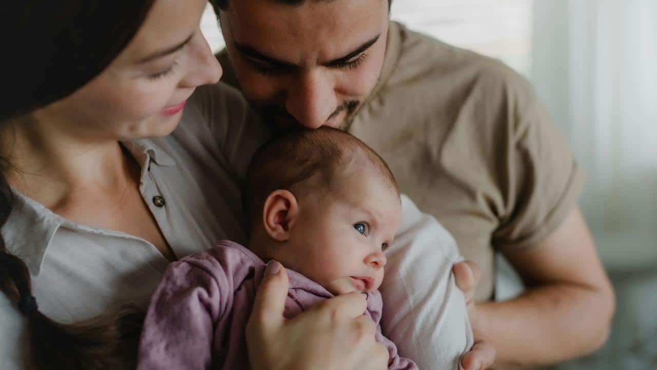 A mother and father holding their newborn baby.