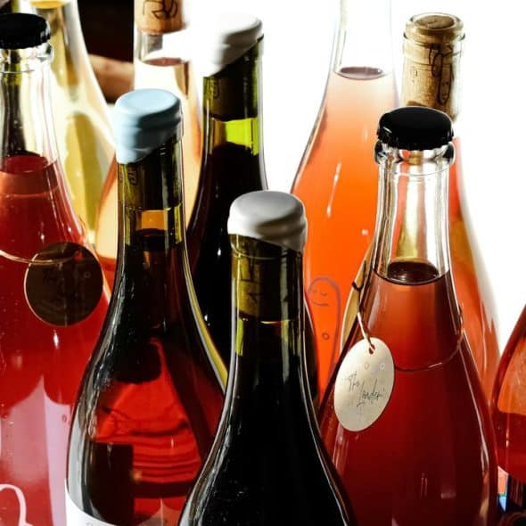 A variety of wine bottles with different colors and labels on a white background.