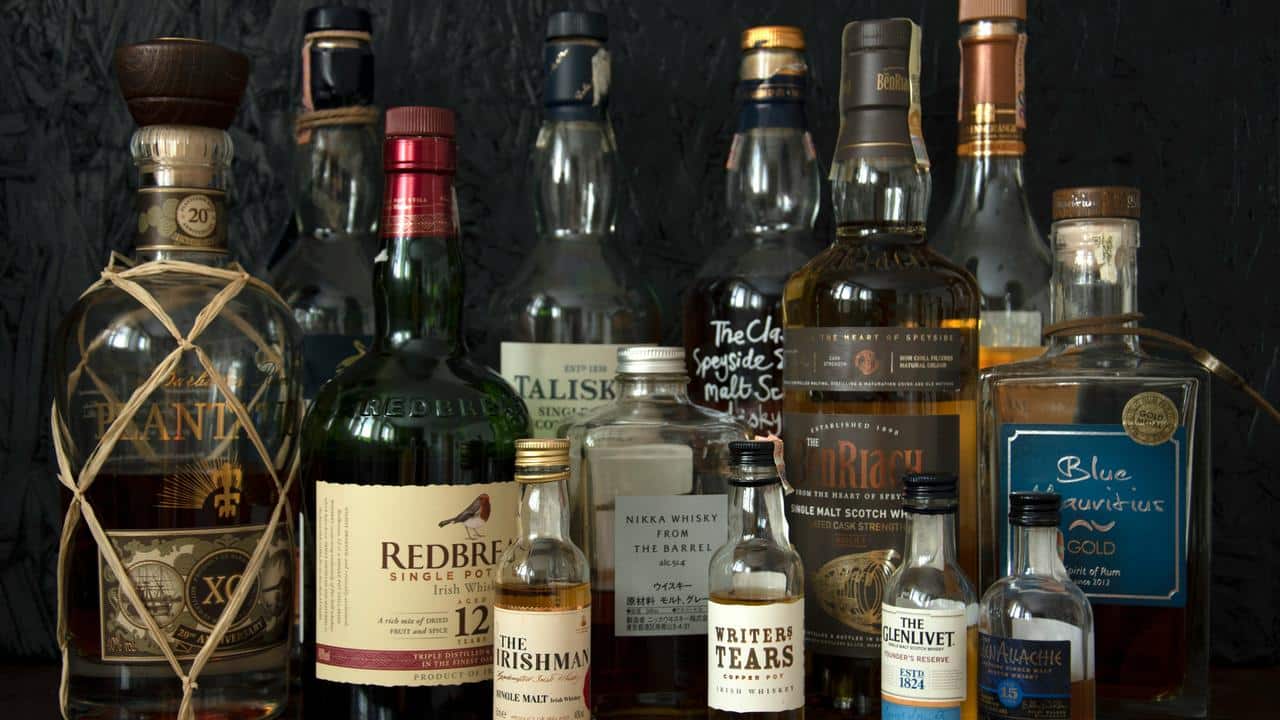 A collection of whiskey and rum bottles on display.