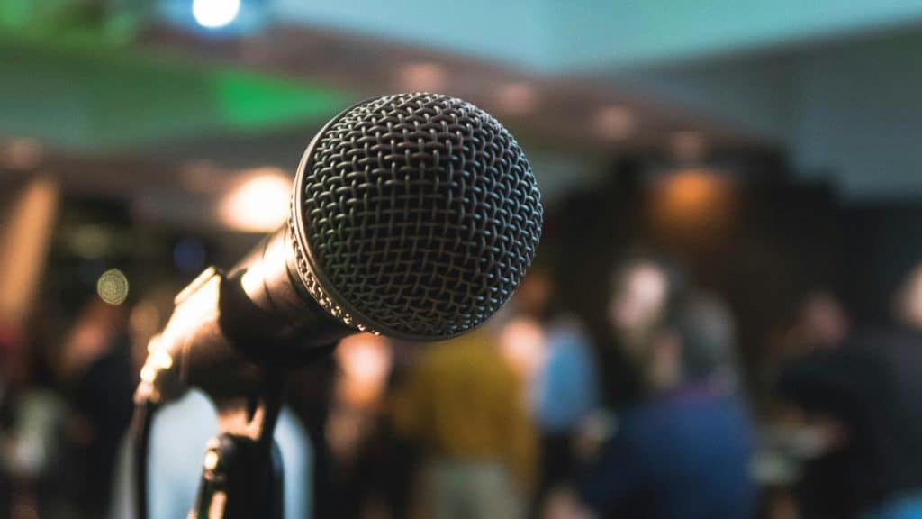 A microphone in front of a blurred audience.