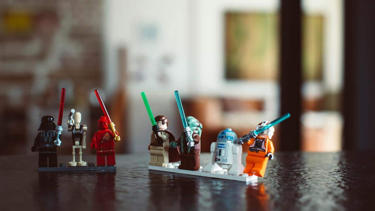 A row of LEGO Star Wars minifigures with lightsabers.