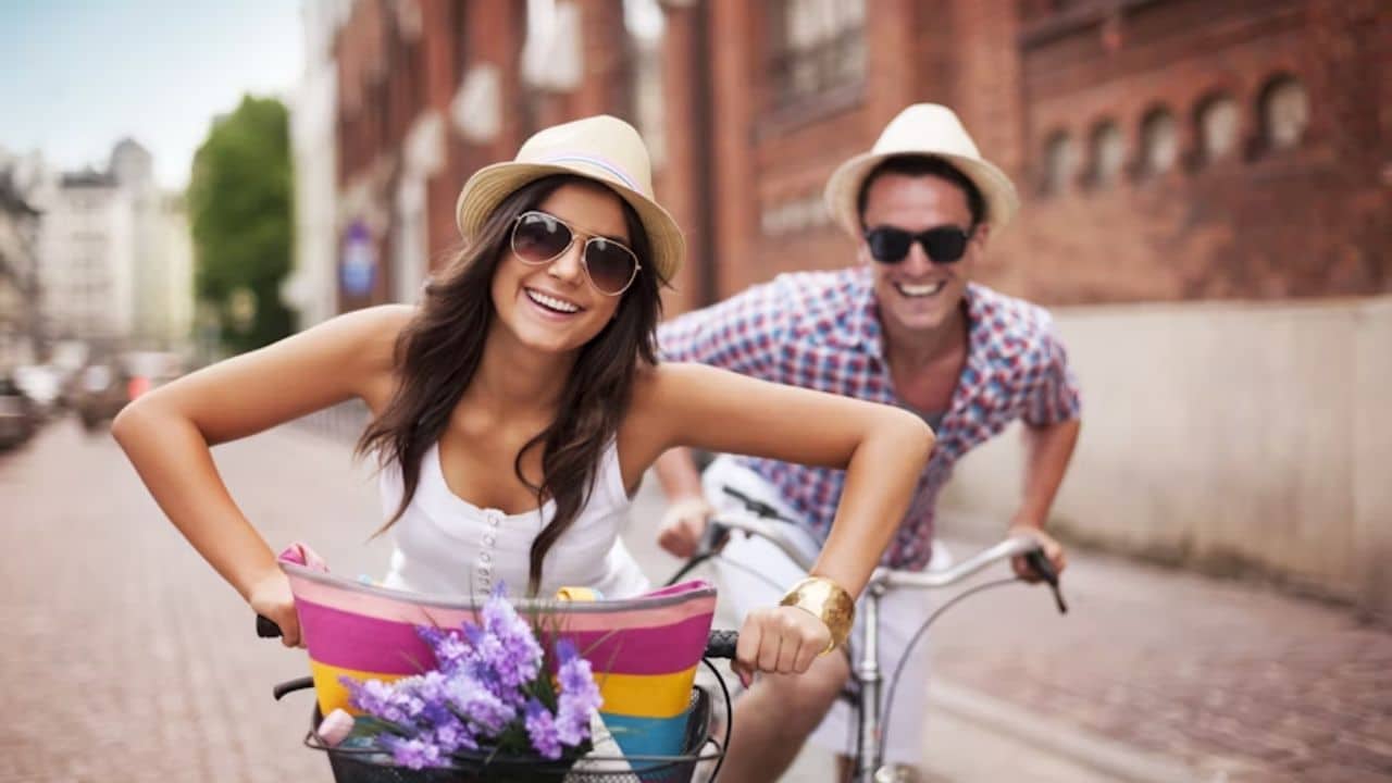 Couple cycling together on a sunny path.