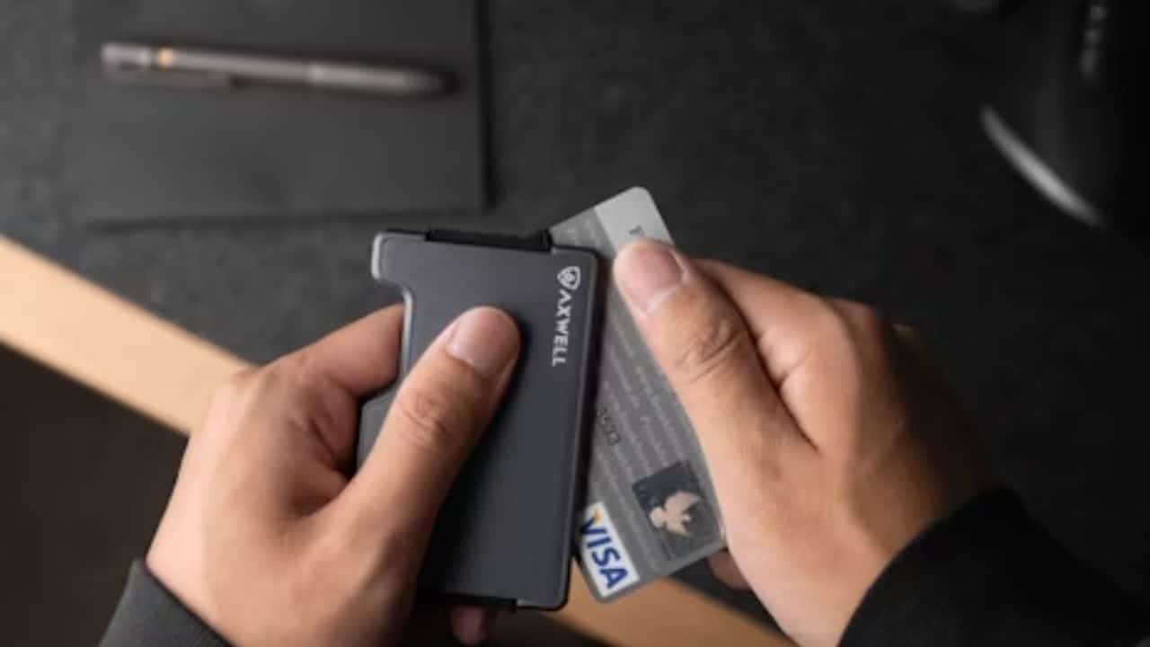 Man planning to cut a credit card at a table.