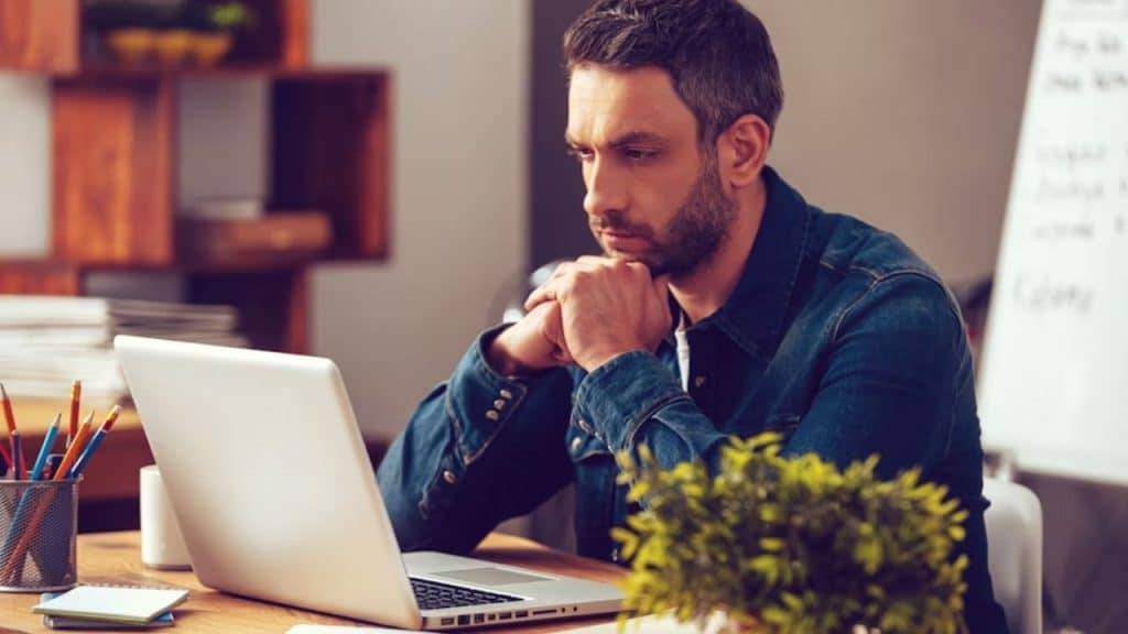Man sitting thoughtfully, considering how to handle a disagreement