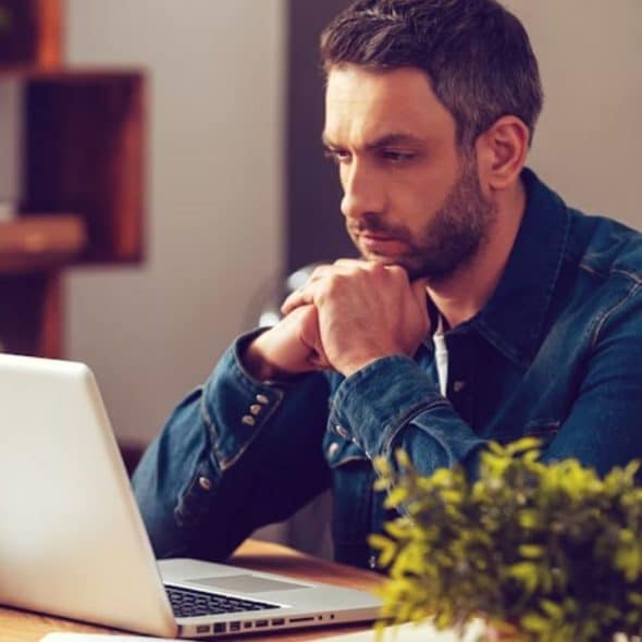 Man sitting thoughtfully, considering how to handle a disagreement