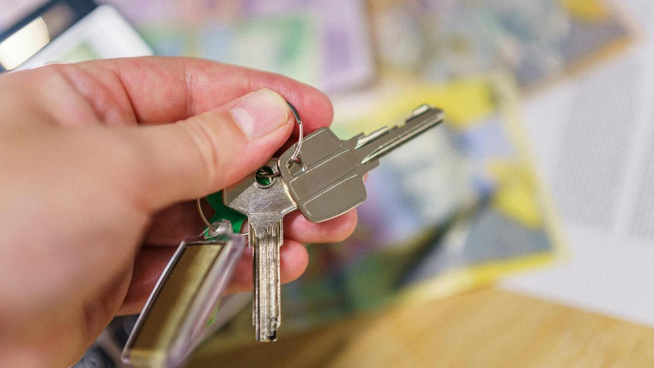 A person’s hand holding a set of house keys.