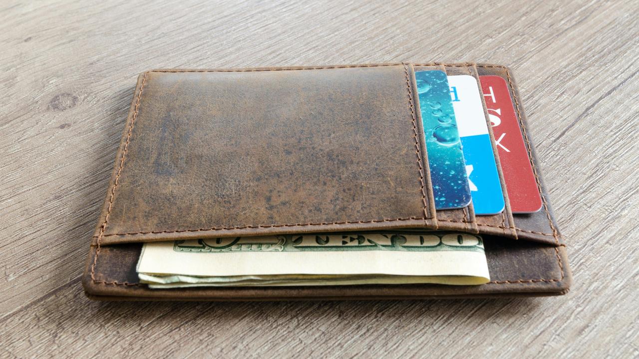 A brown leather wallet with cash and credit cards.