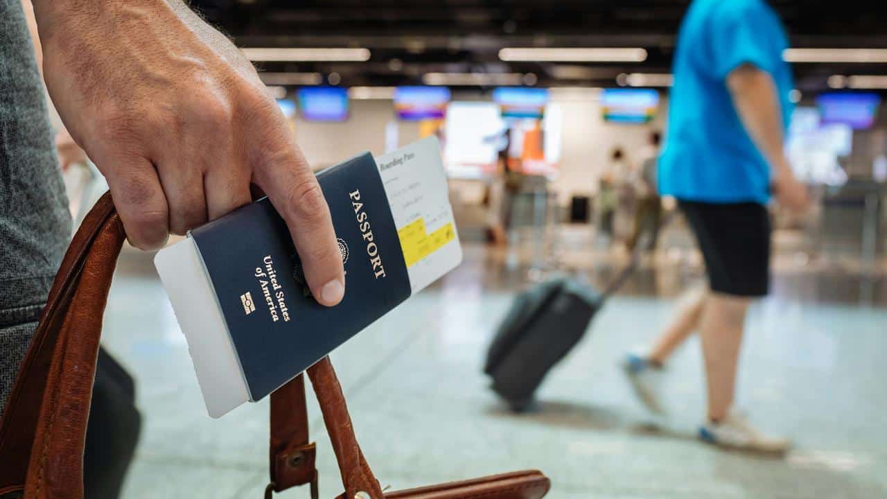 A traveler holding a U.S. passport and boarding pass at an airport.