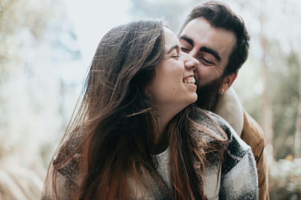 A man kissing a woman on a cheek