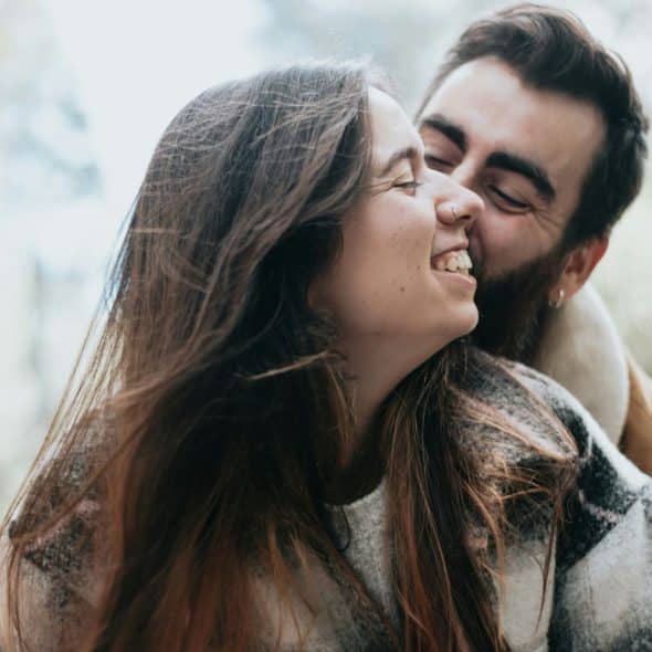 A man kissing a woman on a cheek