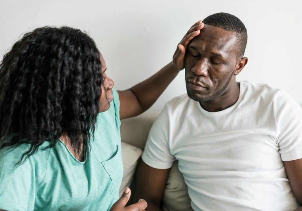 A woman taking care of a sick man