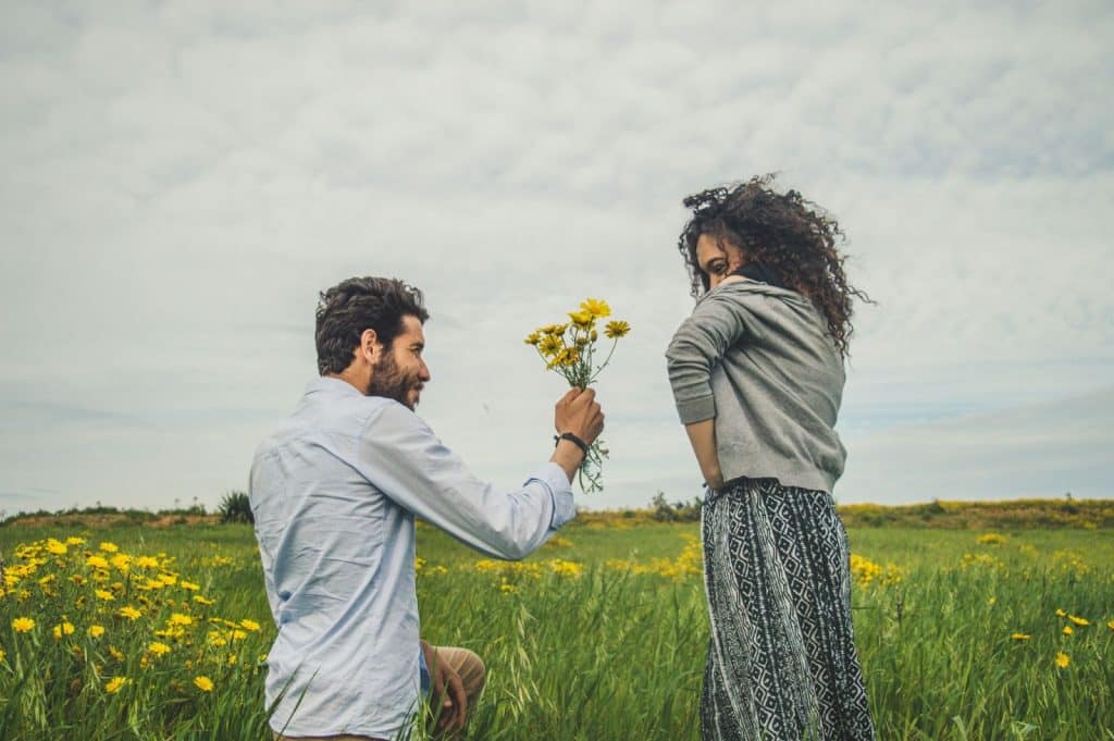 A man giving a flower to a woman