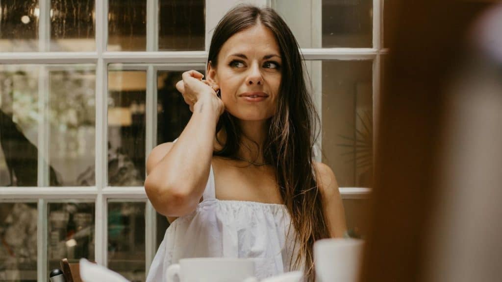 A woman is looking away with a sarcastic smile on her face.