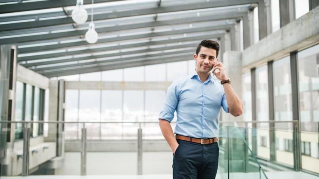 Man standing on rooftop with city skyline, casual but confident