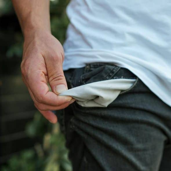 A person showing an empty pocket of their jeans.