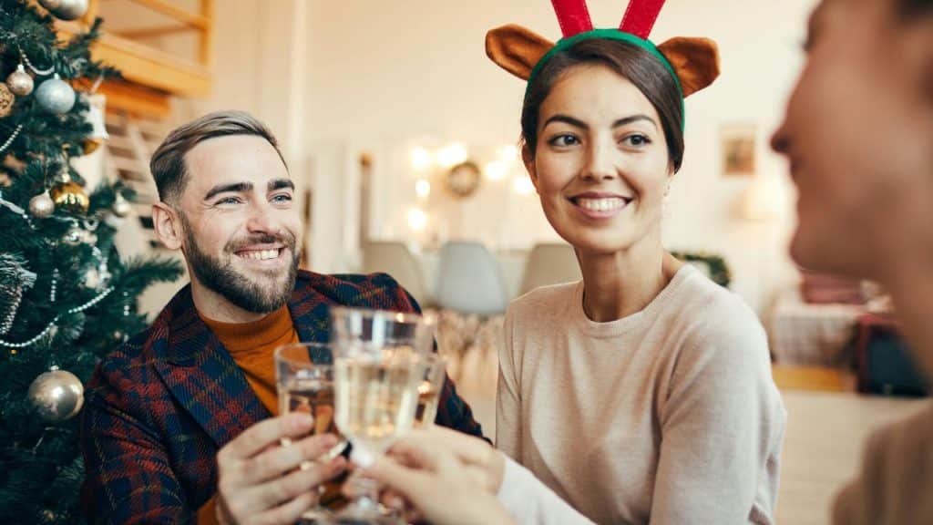 A group toasting drinks at a festive holiday gathering.