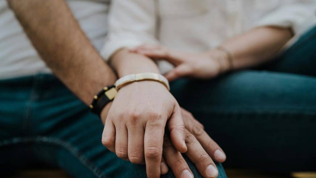 A close-up of two people holding hands.