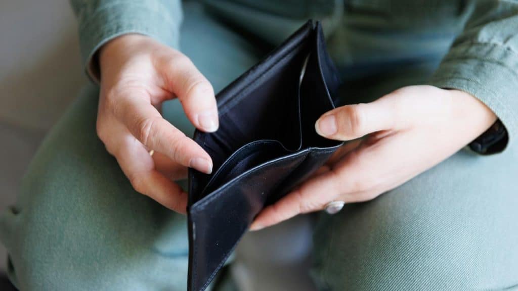 A person holding an open empty wallet.