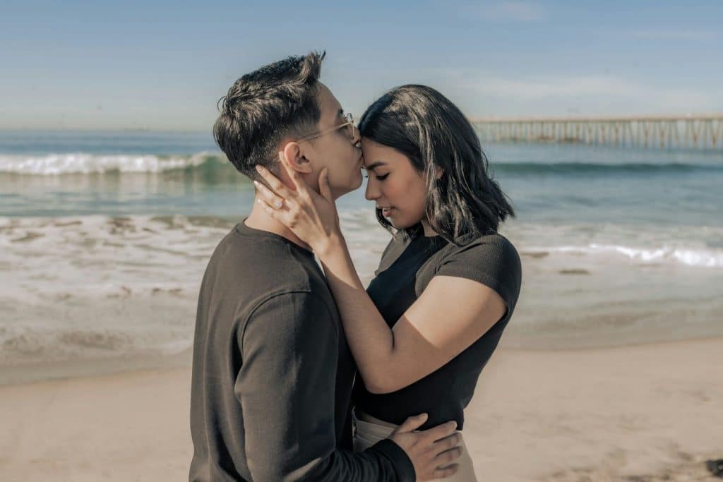 A man kissing a woman’s forehead