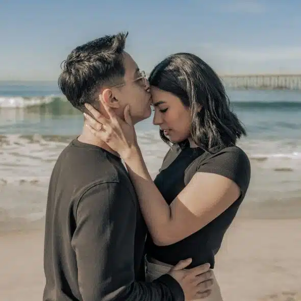 A man kissing a woman’s forehead